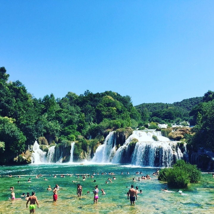 Wide view of a waterfall with lush vegetation.