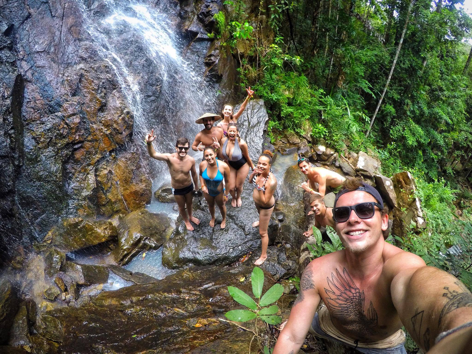 Group of people having fun at a waterfall.