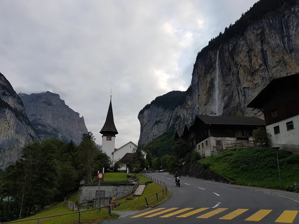 Scenic landscape in a mountainous valley with a church steeple.