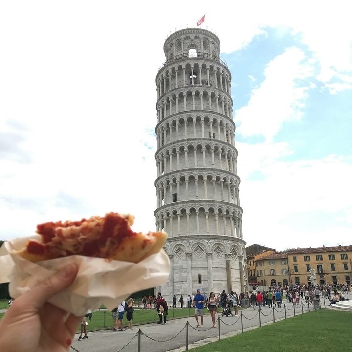 The Leaning Tower of Pisa with a food item in the foreground.