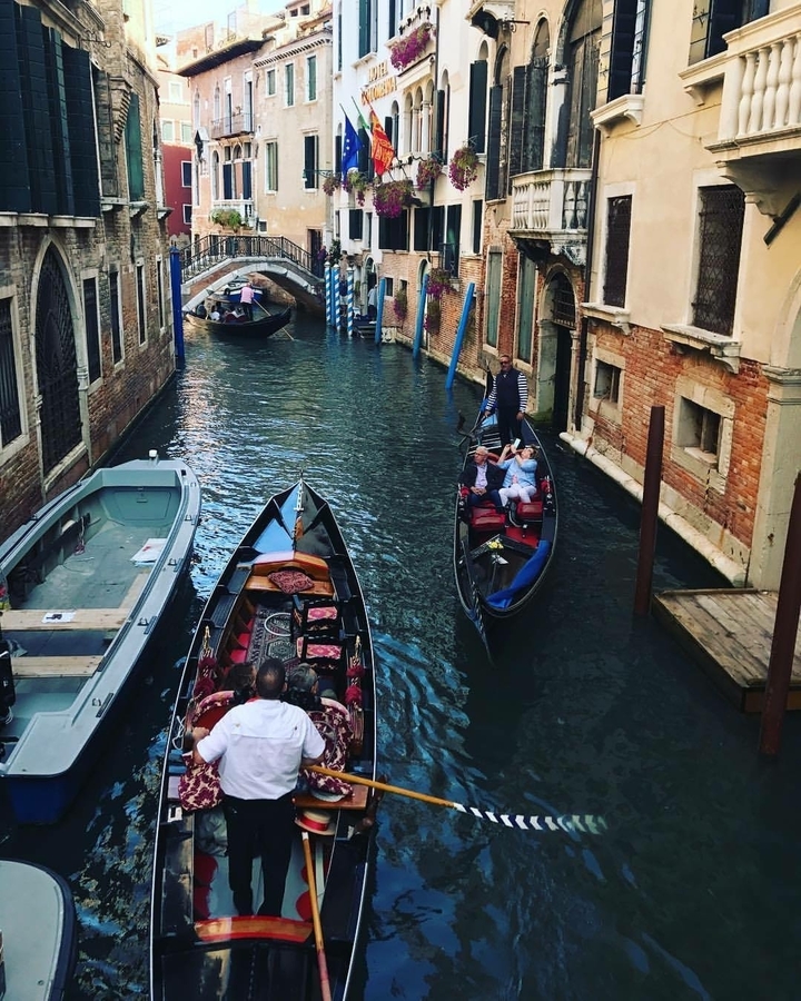 Gondolas navigating a canal in Venice.