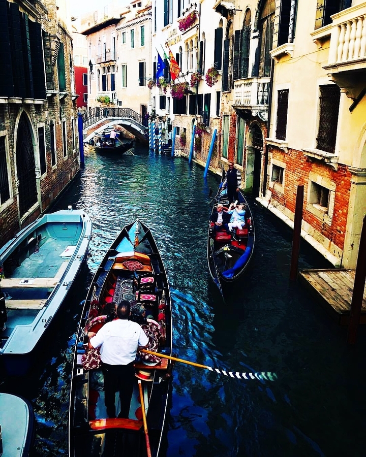 Gondolas navigating a quaint canal in Venice.
