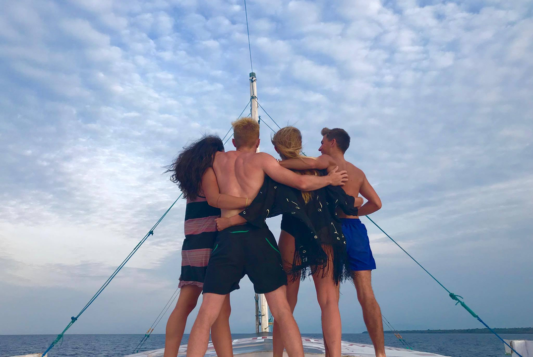 Group of people embracing on a boat at sea.