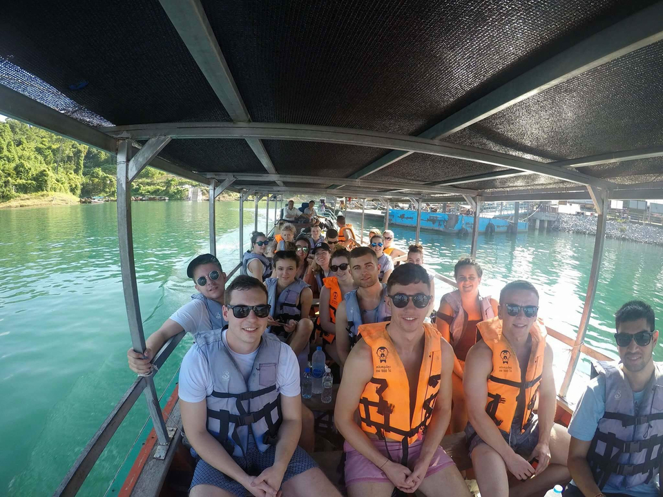 Group of people on a boat ride with life jackets.
