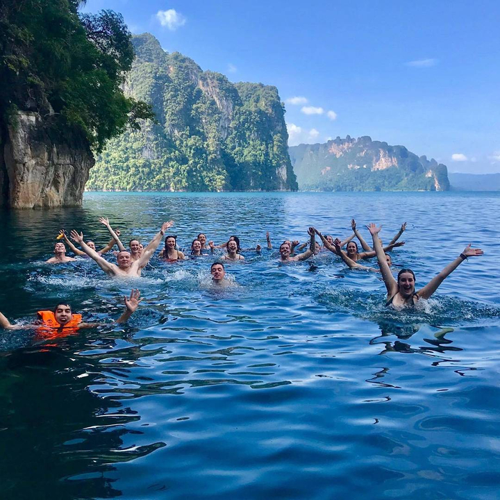 People enjoying swimming in a clear blue lake.