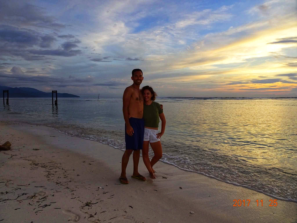 Couple posing on a beach at sunset.