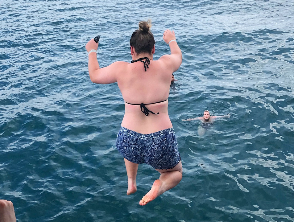 Person jumping into the water from a boat.