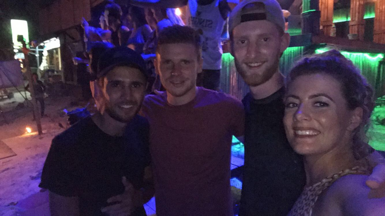 Group of friends together at a night venue with neon lights.