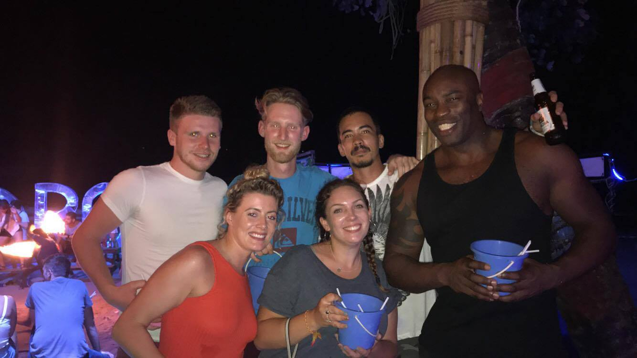 Group of people enjoying a party at night with drinks.