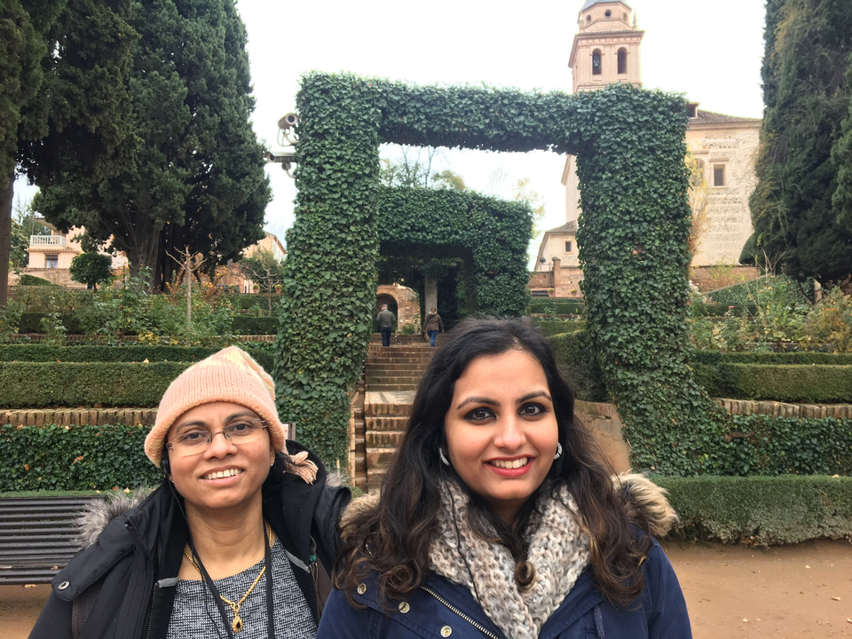 Deux femmes posant dans un jardin avec des marches en pierre et de la verdure.