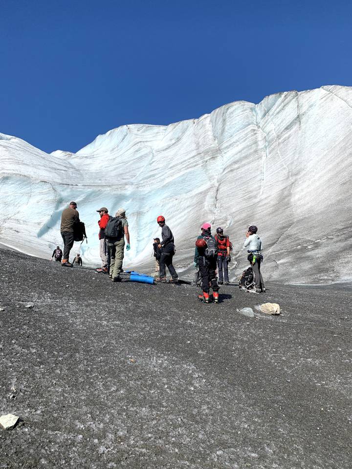 Group of people with climbing gear on a glacier.
