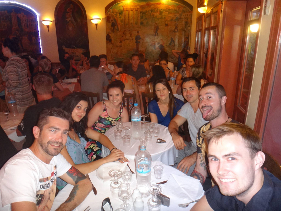 Group of people smiling at a table in a restaurant.