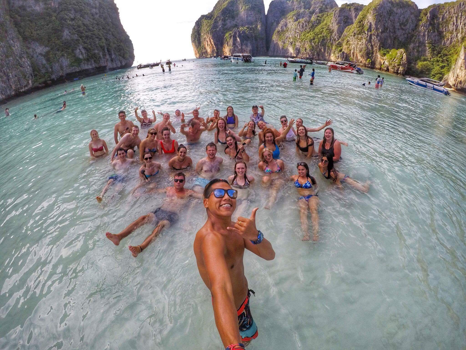 Large group of people in water posing for a selfie.