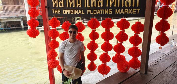 Person standing in front of a sign for a floating market.