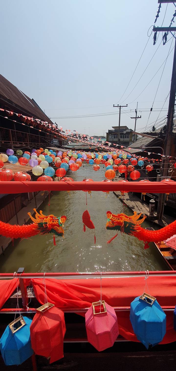 Decorated canal with colorful lanterns hanging overhead.