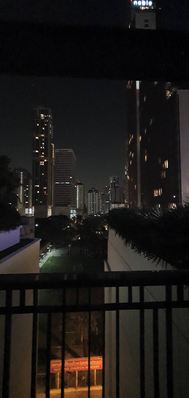 Skyline of a city with tall lit buildings at night.