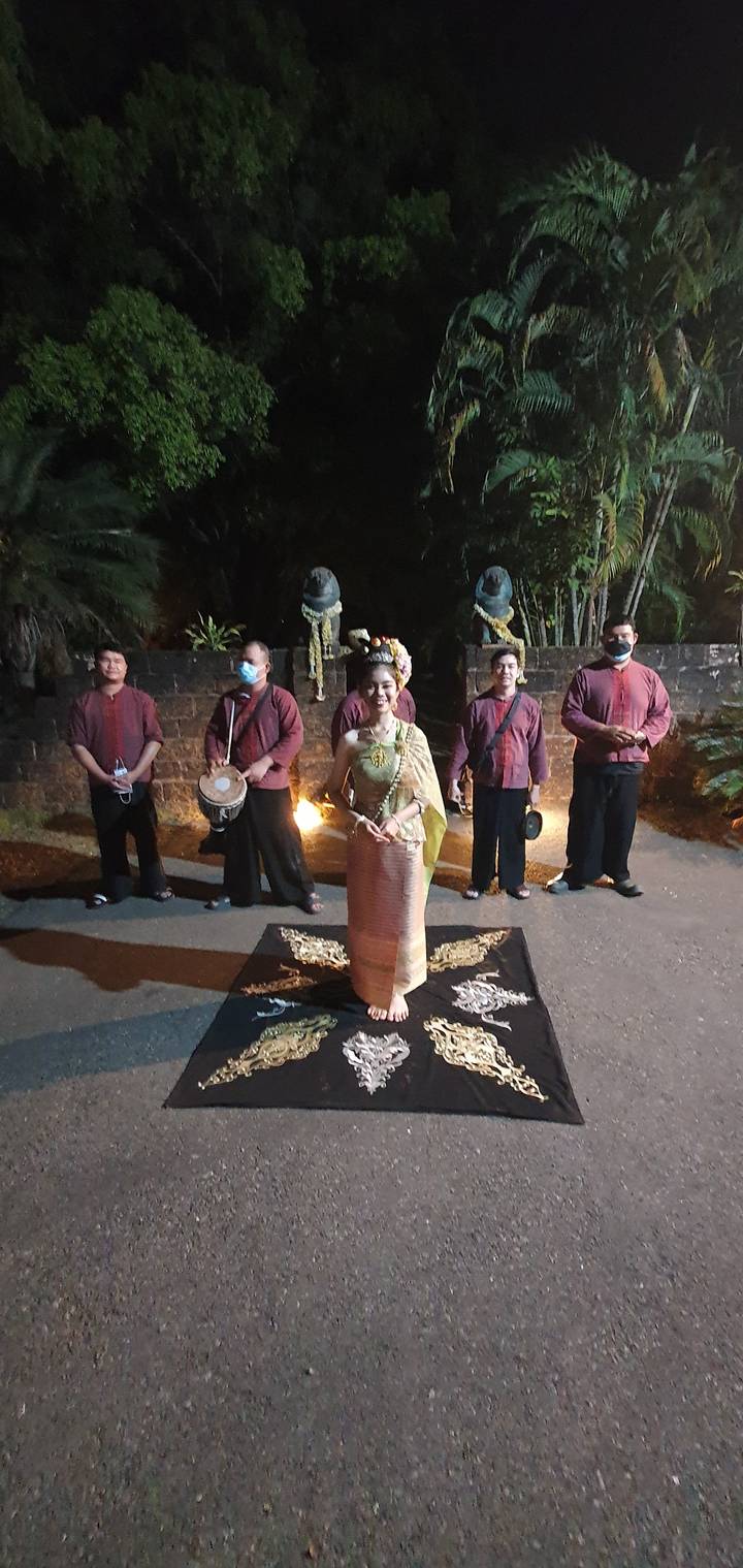 Group of people in traditional clothing at night.