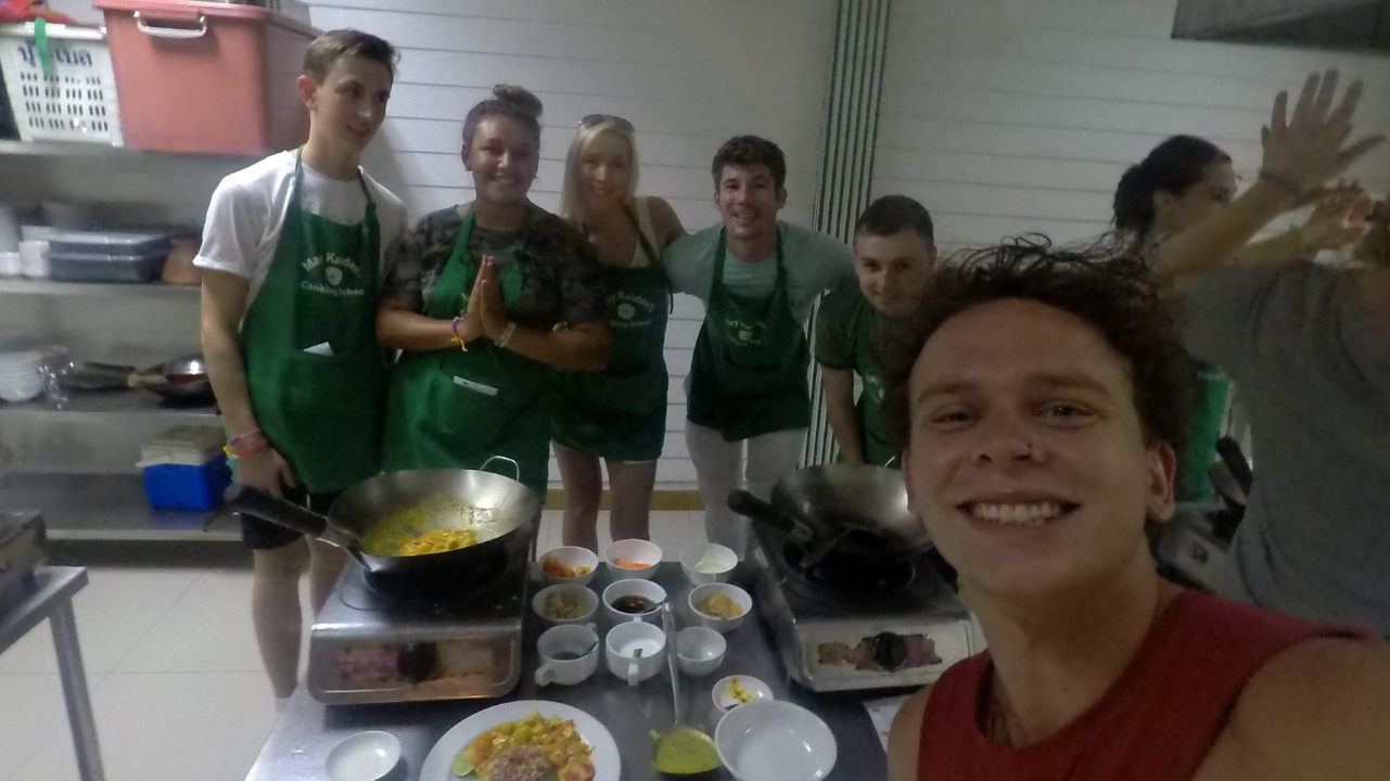 Group cooking class with participants posing for a selfie.