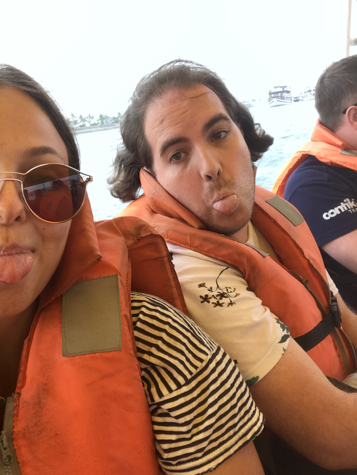 Two people on a boat, playfully making faces.