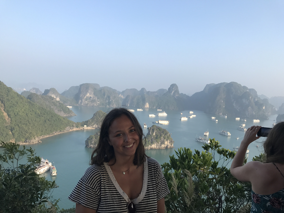 View over a bay with limestone islets and boats.