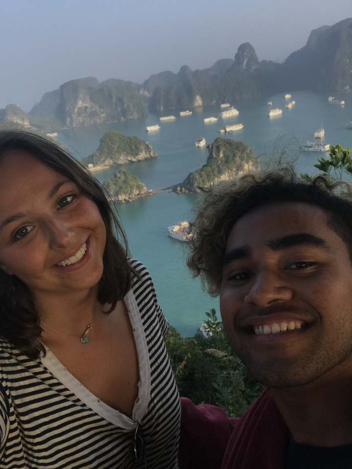 Two people with a scenic view of limestone islands and water.