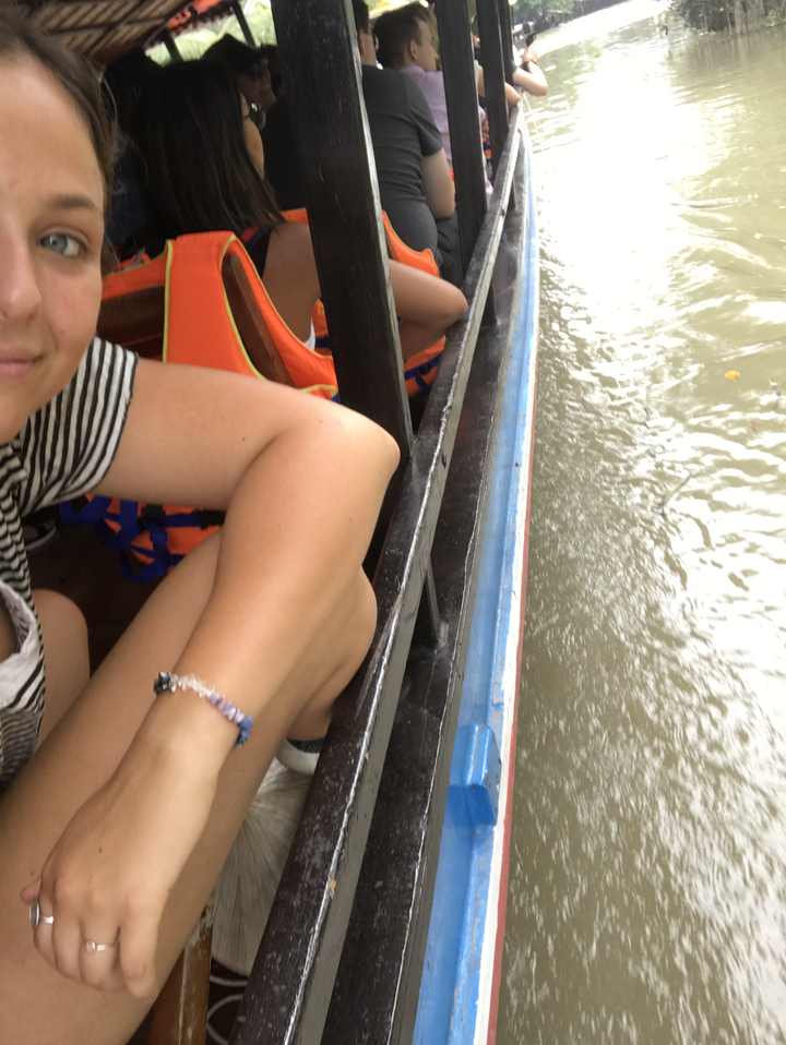 Partial view of a person on a boat with a view of water.