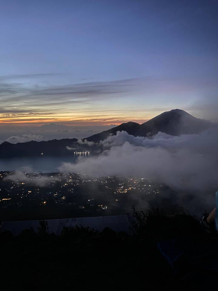 Scenic mountain view at dusk with lights in the valley.
