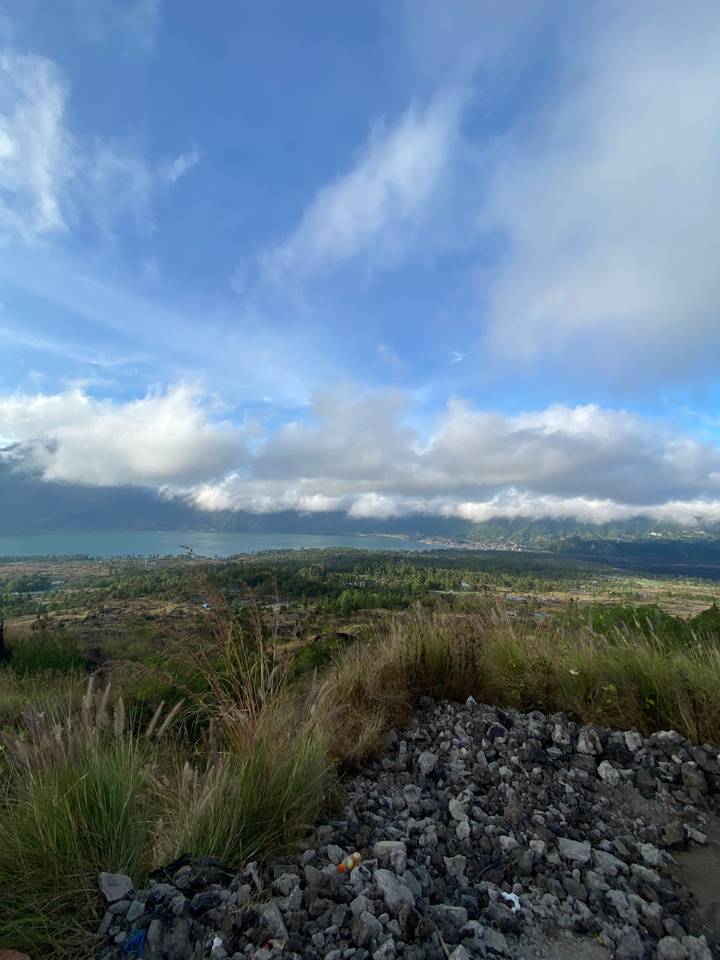 Cloudy sky over a lush landscape with rugged terrain.
