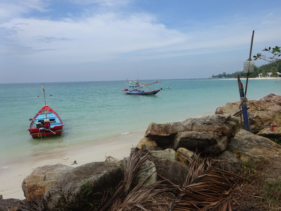 Fishing boats anchored on a sandy beach.