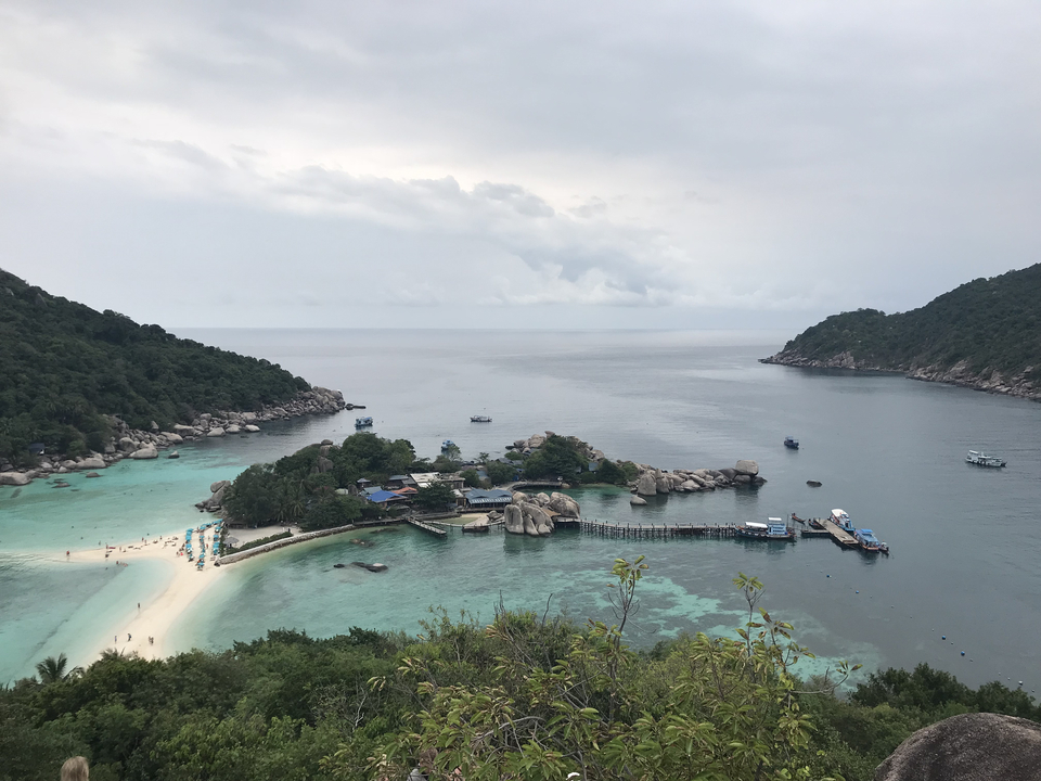 Aerial view of a tropical island with turquoise waters and white sandy beaches.