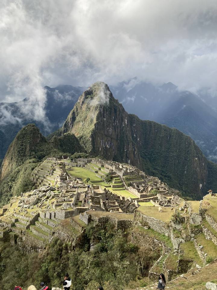 Ancient city ruins in a mountainous jungle setting.