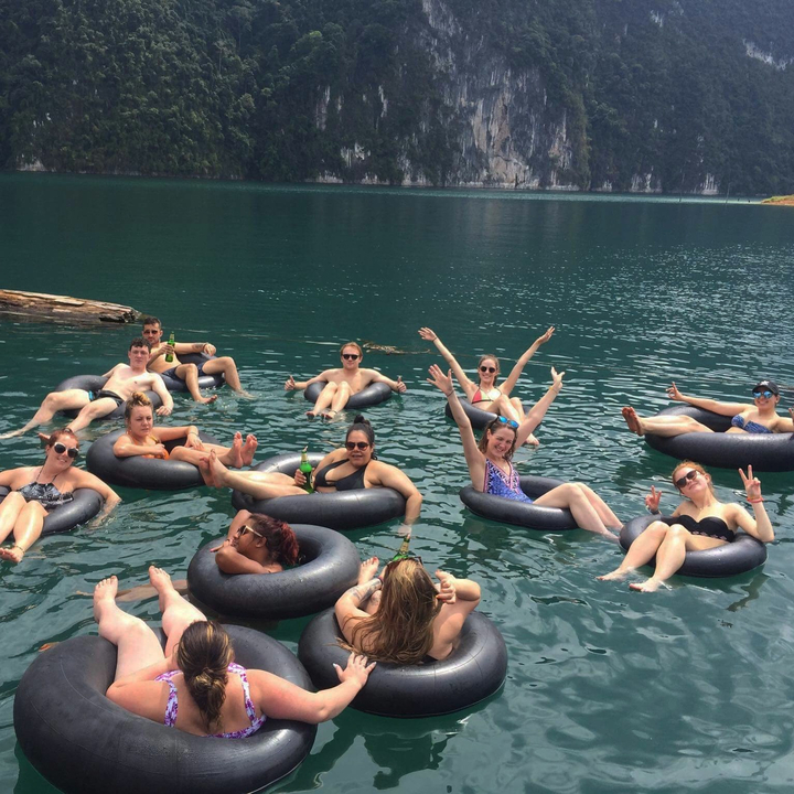 Group of people floating on a lake in inner tubes.