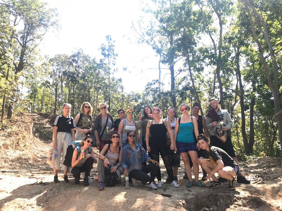 A group of people posing in a forested area.
