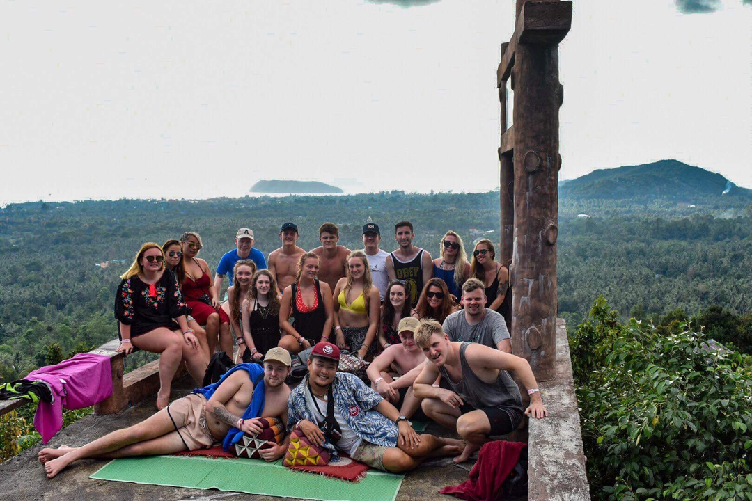 A large group of people at an observation point overlooking a lush landscape.