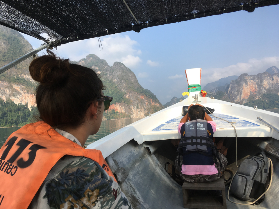 Deux personnes dans un bateau regardant un paysage montagneux.