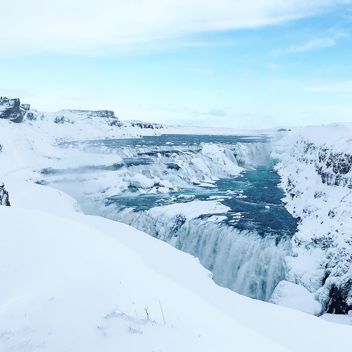 Snow-covered waterfall landscape with ice formations.