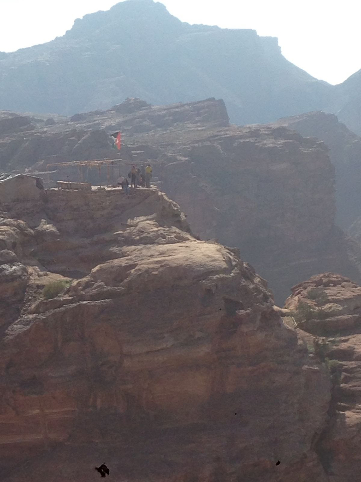 People on a cliff with a makeshift viewing platform.