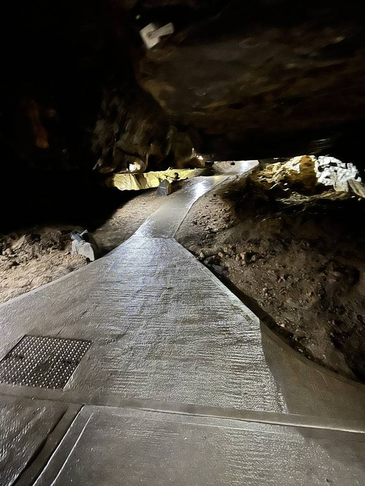 Rocky cave passage with a glowing path.