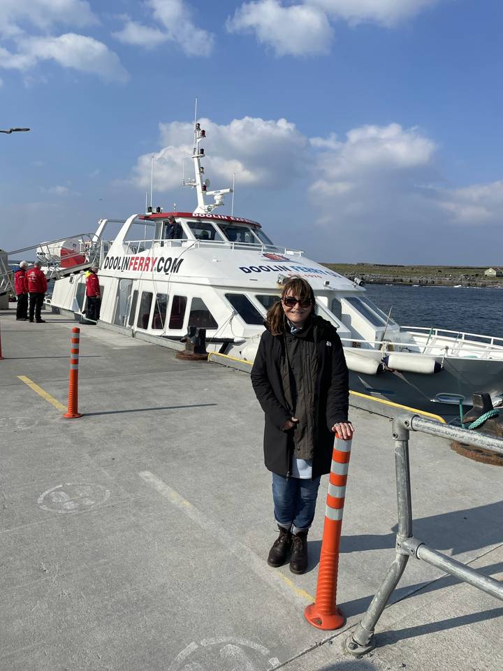 Person standing near a ferry with a cone on the dock.