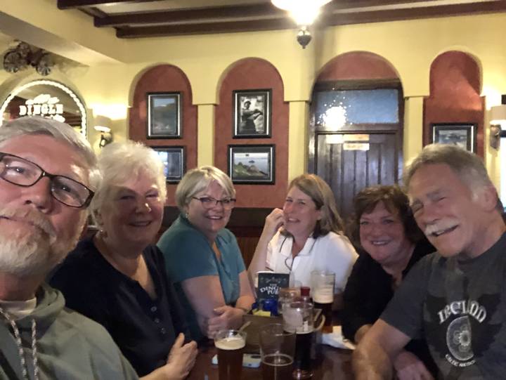 Group of people enjoying drinks inside a pub.