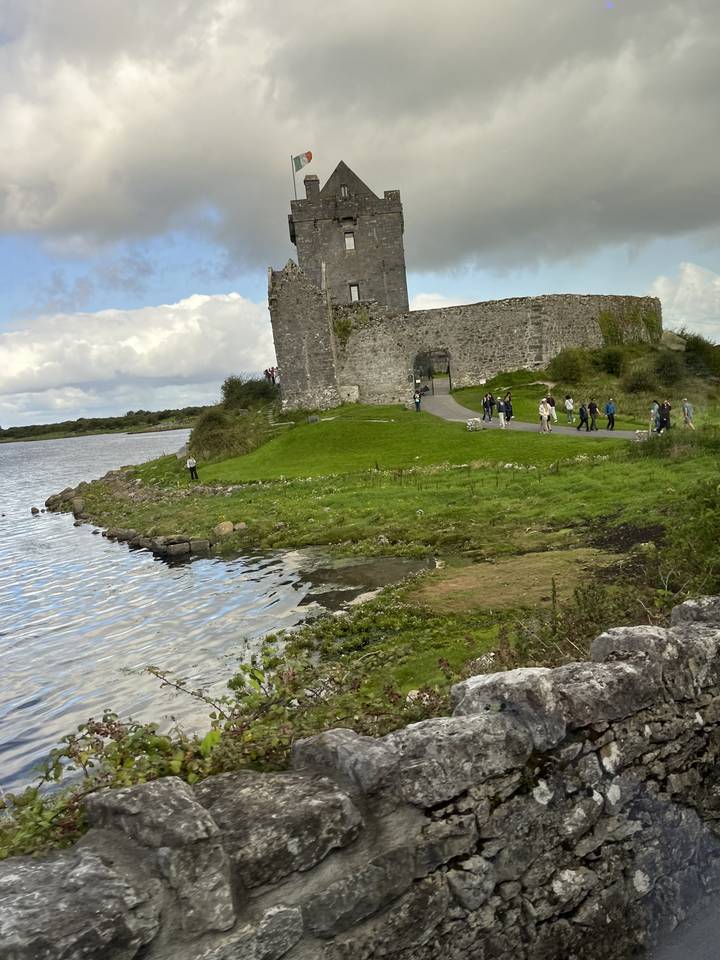 Castle and river with people walking nearby