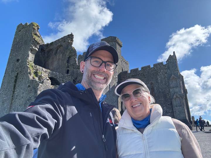 Couple posing in front of a historic castle.