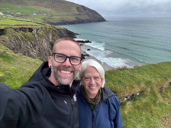 Couple posing with a coastal view in background.
