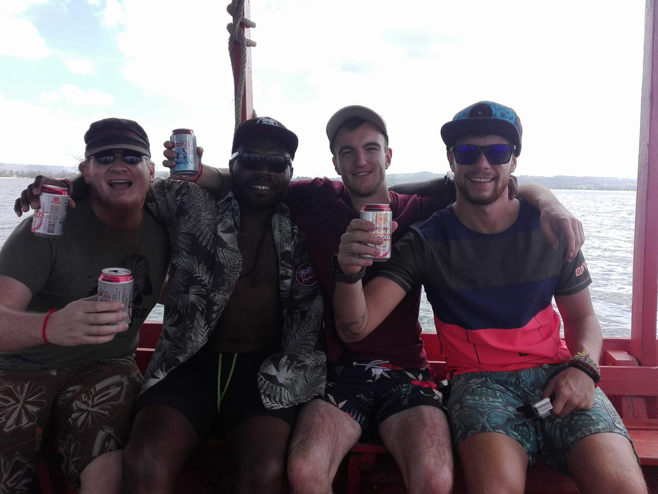 Group of friends enjoying drinks on a boat.