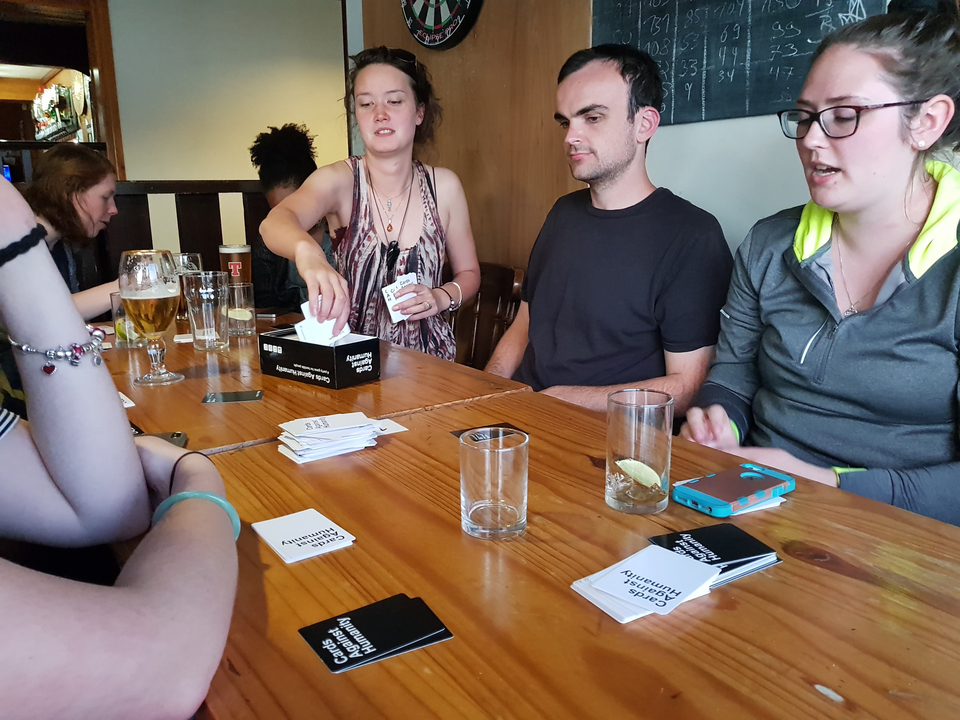 Group of people playing a card game indoors.