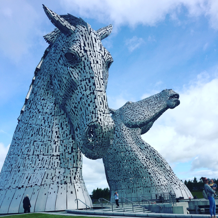 Close-up of the Kelpies sculptures under a blue sky.