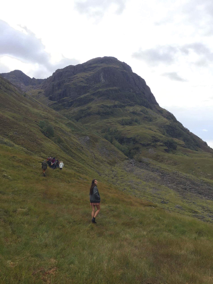 Hikers ascending a grassy hillside with beautiful scenery.