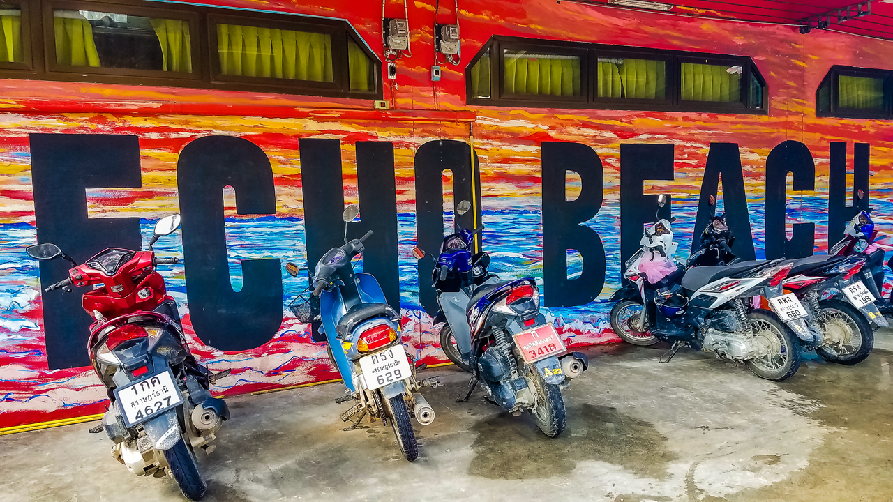Mural with the text 'ECHO BEACH' with parked scooters.