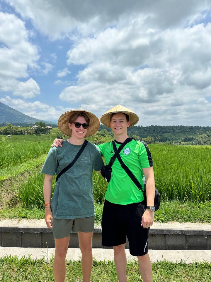 Two people wearing traditional hats posing outdoors.