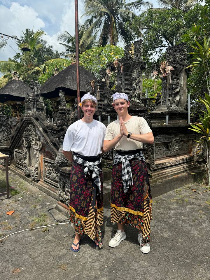 Two people in traditional attire posing at a temple.